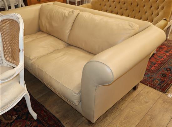 A putty coloured leather two seater settee